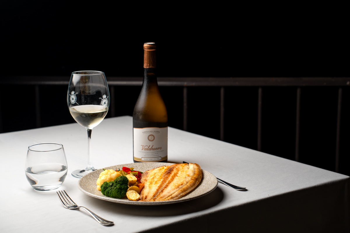 Cena de pescado acompañada de vino