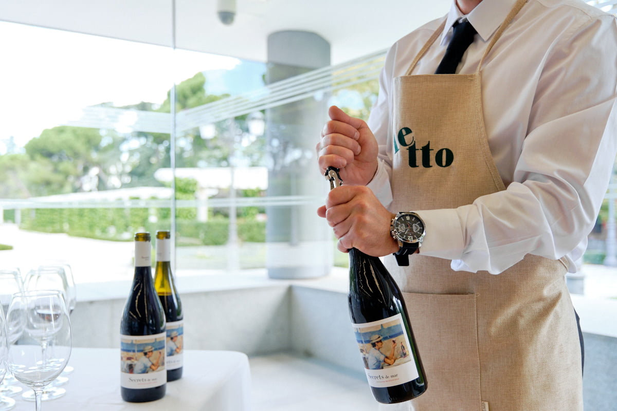 Camarero abriendo botella de vino