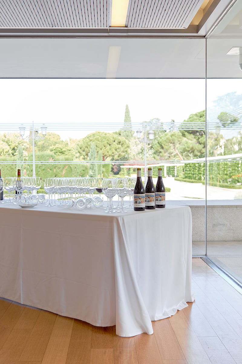 Mesa de cátering con botellas de vino y copas Mesa de catering con botellas de vino y copas