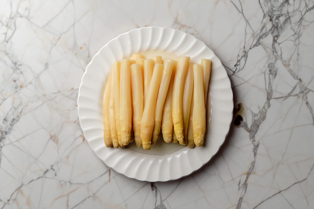 Plato de espárragos sobre superficie de mármol Plato de espárragos sobre superficie de mármol