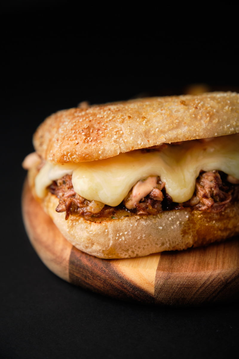 Sandwich cubano con queso sobre tabla de madera